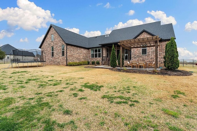 view of front of house featuring a trampoline, a pergola, a front lawn, a patio area, and fence