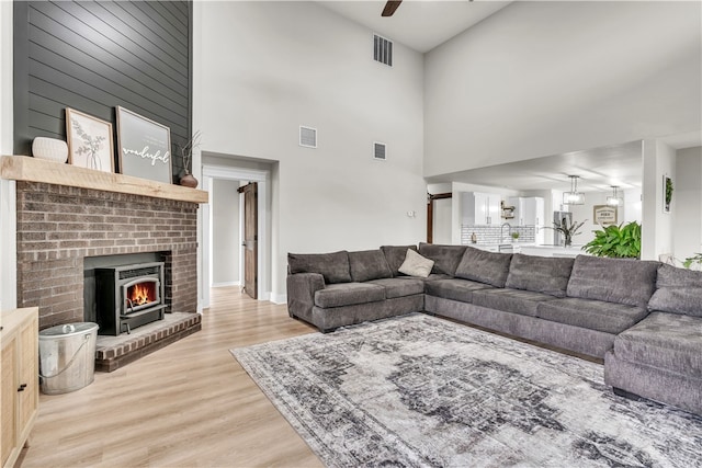 17225 Featherstone Trl, Gentry, AR 72734 - living room with visible vents, a ceiling fan, wood finished floors, and a brick fireplace