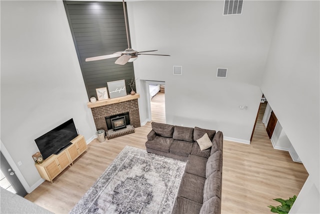 17225 Featherstone Trl, Gentry, AR 72734 - living area with visible vents, a ceiling fan, a towering ceiling, and a brick fireplace