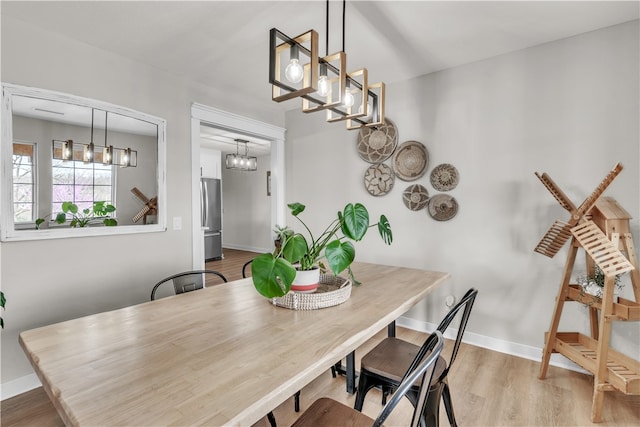 17225 Featherstone Trl, Gentry, AR 72734 - dining area with baseboards, light wood-style flooring, and a chandelier