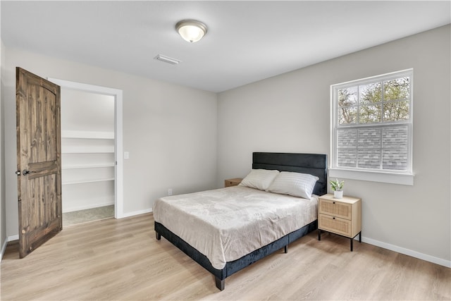 17225 Featherstone Trl, Gentry, AR 72734 - bedroom featuring baseboards, visible vents, a walk in closet, and light wood finished floors