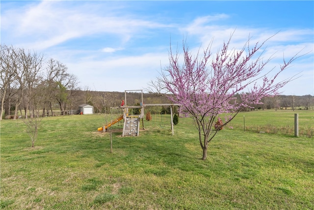 17225 Featherstone Trl, Gentry, AR 72734 - view of yard with a storage unit, an outdoor structure, a rural view, and a playground