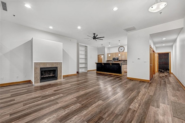 321 E Lafayette St Unit 103, Fayetteville, AR 72701 - unfurnished living room with dark wood-style floors, a fireplace, baseboards, a ceiling fan, and built in features