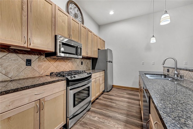 321 E Lafayette St Unit 103, Fayetteville, AR 72701 - kitchen featuring stainless steel appliances, a sink, decorative backsplash, light brown cabinetry, and baseboards