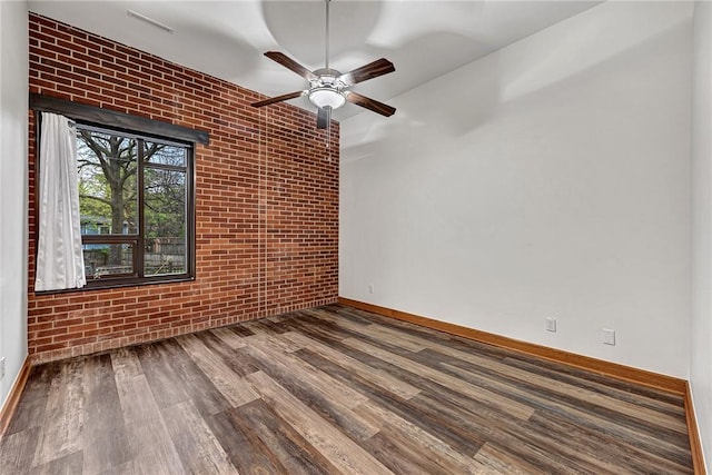 321 E Lafayette St Unit 103, Fayetteville, AR 72701 - unfurnished room featuring brick wall, wood finished floors, baseboards, and a ceiling fan