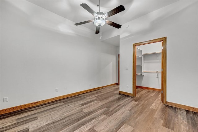 321 E Lafayette St Unit 103, Fayetteville, AR 72701 - unfurnished bedroom featuring wood finished floors, baseboards, a spacious closet, a closet, and ceiling fan