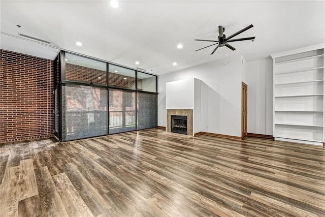321 E Lafayette St Unit 103, Fayetteville, AR 72701 - unfurnished living room featuring wood finished floors, recessed lighting, ceiling fan, a fireplace, and brick wall