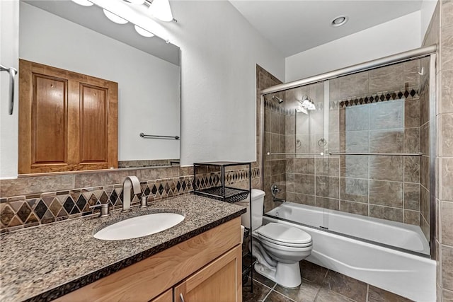 321 E Lafayette St Unit 103, Fayetteville, AR 72701 - bathroom featuring toilet, bath / shower combo with glass door, vanity, backsplash, and tile patterned floors