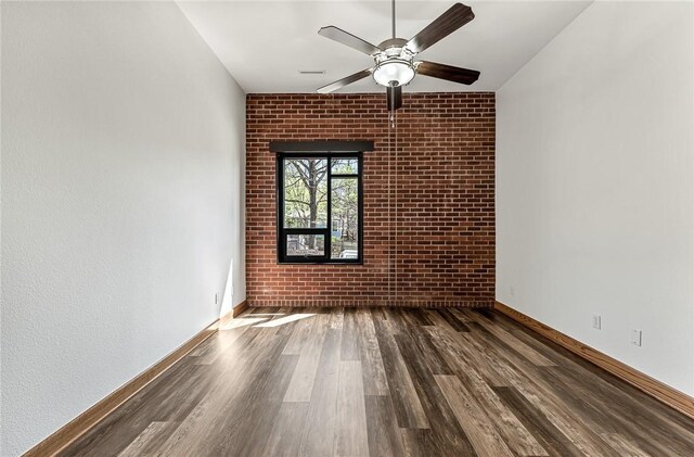 321 E Lafayette St Unit 103, Fayetteville, AR 72701 - empty room with wood finished floors, a ceiling fan, baseboards, and brick wall