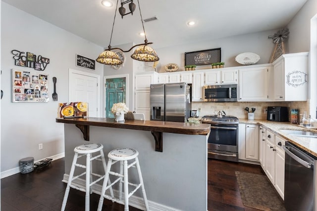 6628 Bernice Ave, Springdale, AR 72762 - kitchen featuring stainless steel appliances, decorative backsplash, white cabinets, dark wood-style flooring, and recessed lighting