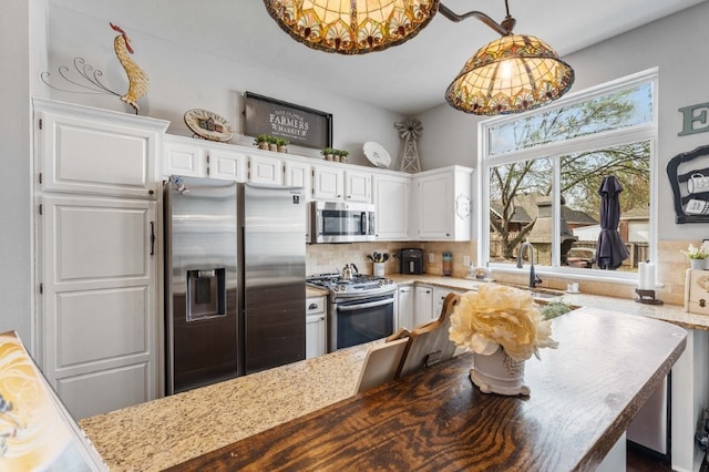 6628 Bernice Ave, Springdale, AR 72762 - kitchen with appliances with stainless steel finishes, white cabinetry, backsplash, a chandelier, and decorative light fixtures