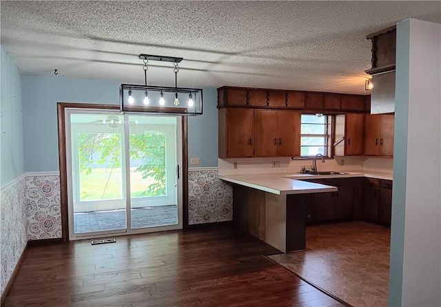 1003 Freeman Ave, Berryville, AR 72616 - kitchen with a peninsula, dark wood finished floors, light countertops, a sink, and a textured ceiling