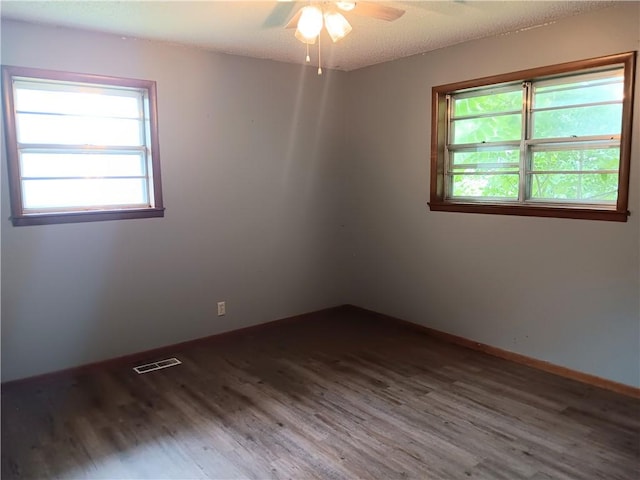 1003 Freeman Ave, Berryville, AR 72616 - unfurnished room featuring wood finished floors, plenty of natural light, and ceiling fan