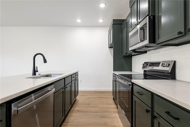 730 N 5th St, Rogers, AR 72756 - kitchen featuring appliances with stainless steel finishes, light countertops, backsplash, light wood finished floors, and recessed lighting