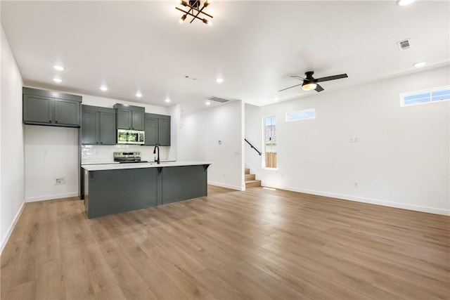 730 N 5th St, Rogers, AR 72756 - kitchen featuring appliances with stainless steel finishes, light countertops, light wood-style flooring, backsplash, and recessed lighting