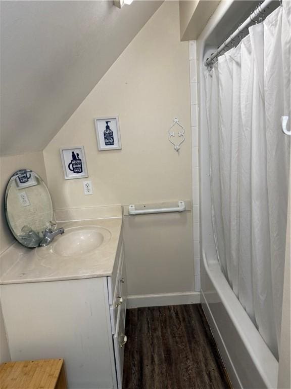 2110 W 8th St, Russellville, AR 72801 - full bathroom with vanity, wood finished floors, shower / bath combination with curtain, vaulted ceiling, and baseboards