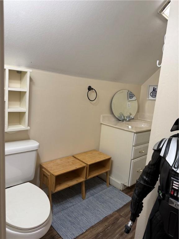 2110 W 8th St, Russellville, AR 72801 - half bath with vanity, lofted ceiling, toilet, and wood finished floors