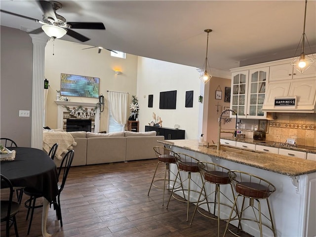 2110 W 8th St, Russellville, AR 72801 - kitchen featuring a kitchen bar, tasteful backsplash, cooktop, a ceiling fan, and glass insert cabinets