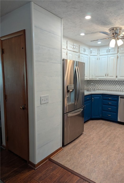 2230 Reed Ave, Springdale, AR 72764 - kitchen featuring dark wood finished floors, white cabinetry, light countertops, appliances with stainless steel finishes, and blue cabinetry