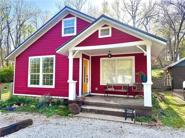 view of front of home featuring a porch and fence