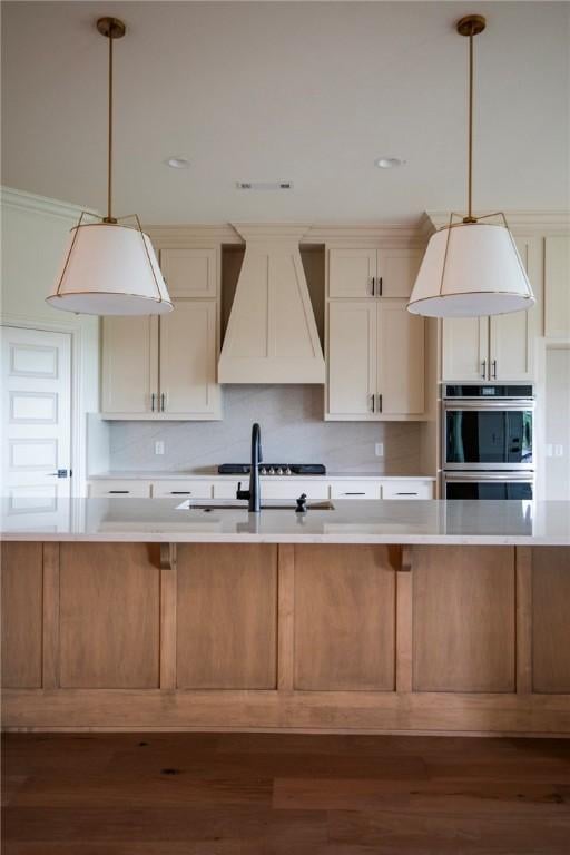 kitchen featuring double oven, light countertops, custom range hood, a sink, and dark wood finished floors