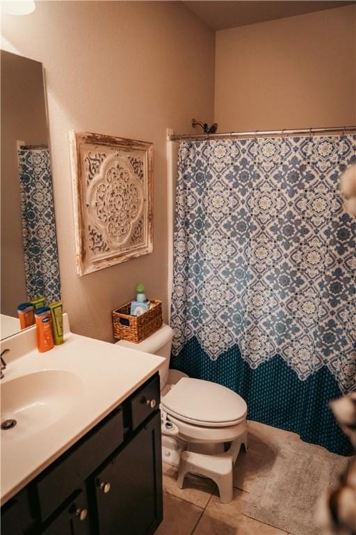 bathroom featuring toilet, vanity, curtained shower, and tile patterned floors