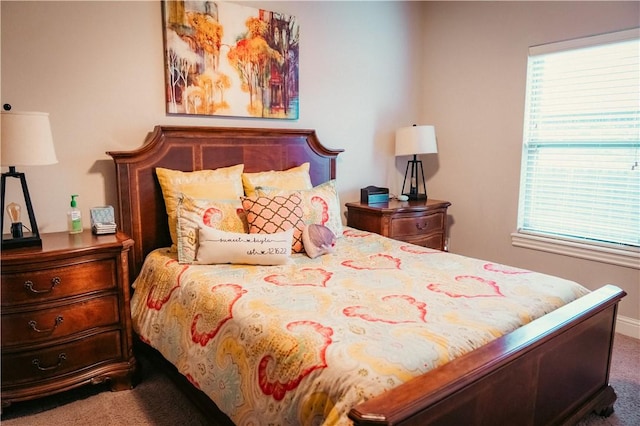 bedroom with baseboards, multiple windows, and carpet flooring