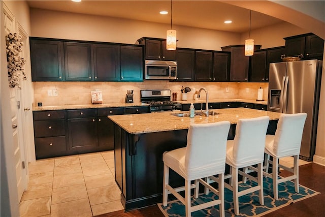 kitchen with stainless steel appliances, backsplash, arched walkways, and a sink
