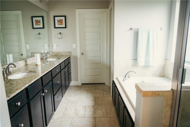 bathroom featuring a bath, double vanity, and a sink