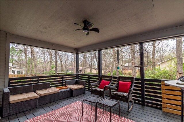 sunroom with outdoor lounge area, a ceiling fan, and a healthy amount of sunlight