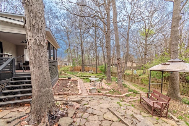 view of yard with a gazebo, a patio, a fenced backyard, and stairs