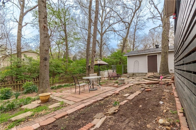 view of yard with an outbuilding, fence, and a patio