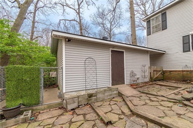 view of outdoor structure featuring an outbuilding, fence, and a gate