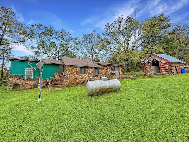 rear view of house featuring stone siding and a lawn