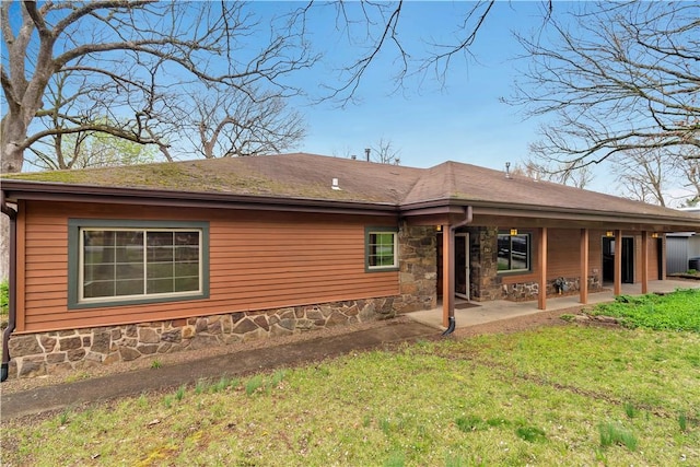 203 N Oklahoma Way, Fayetteville, AR 72701 - back of house featuring stone siding, a patio area, and a yard
