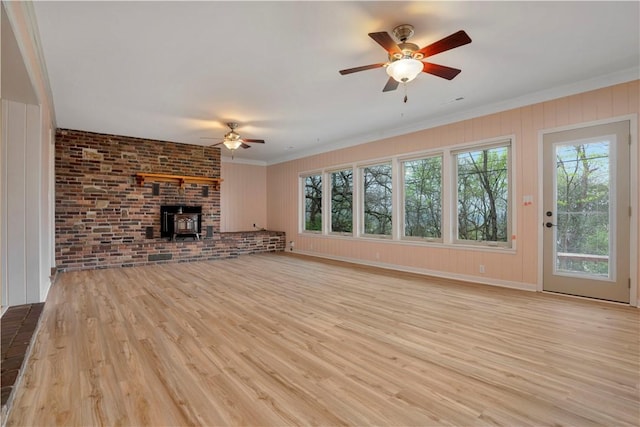 203 N Oklahoma Way, Fayetteville, AR 72701 - unfurnished living room with ceiling fan, plenty of natural light, light wood-type flooring, a wood stove, and crown molding