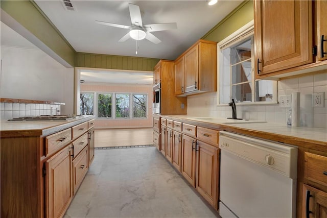 203 N Oklahoma Way, Fayetteville, AR 72701 - kitchen with white dishwasher, a sink, stainless steel gas cooktop, decorative backsplash, and a ceiling fan