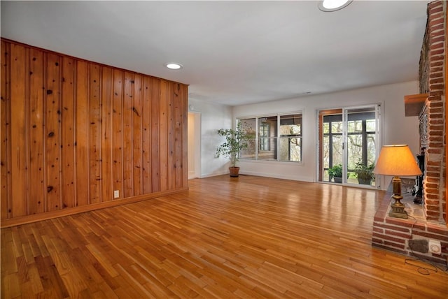 203 N Oklahoma Way, Fayetteville, AR 72701 - unfurnished living room featuring wood finished floors, recessed lighting, baseboards, and wood walls