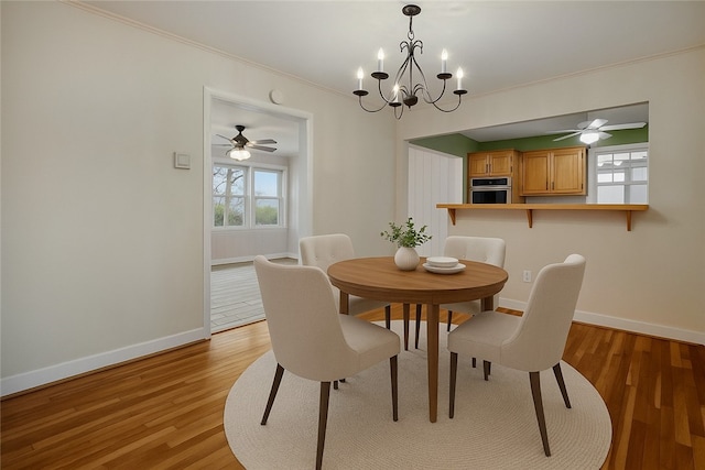 203 N Oklahoma Way, Fayetteville, AR 72701 - dining area featuring light wood-style floors, baseboards, crown molding, and a chandelier