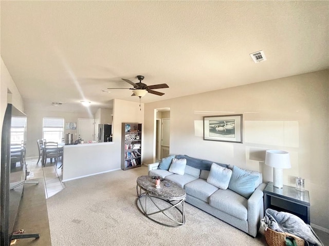 817 Evans Cir, Bentonville, AR 72713 - living area featuring visible vents, baseboards, ceiling fan, a textured ceiling, and light colored carpet