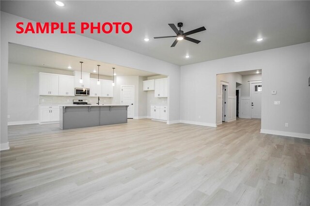 unfurnished living room featuring recessed lighting, light wood-style flooring, baseboards, and ceiling fan