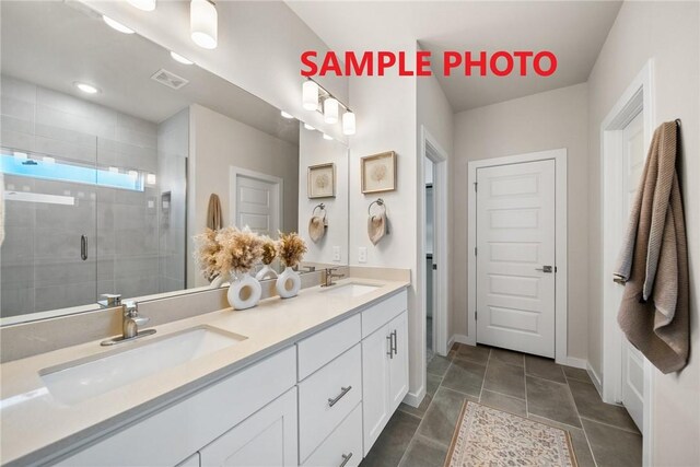 bathroom featuring double vanity, a shower stall, visible vents, and a sink