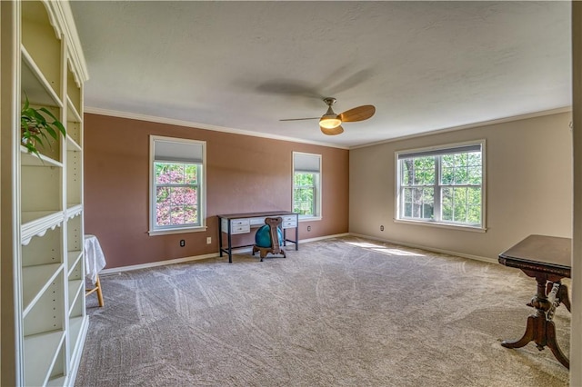 interior space featuring crown molding, baseboards, a ceiling fan, and carpet flooring
