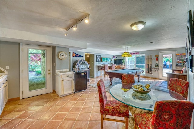 dining space featuring a textured ceiling, billiards, and light tile patterned flooring