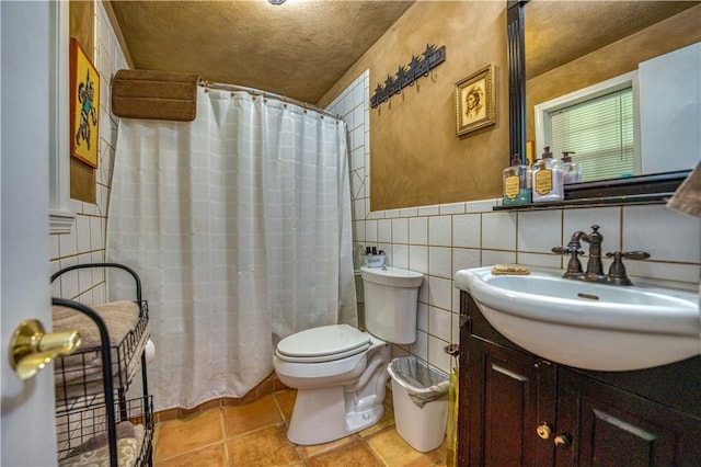 full bathroom with vanity, a wainscoted wall, toilet, curtained shower, and tile walls