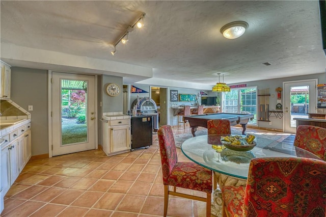 dining space featuring light tile patterned floors, billiards, and a textured ceiling