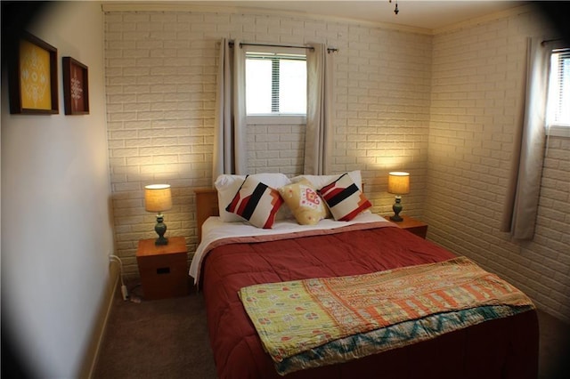 carpeted bedroom with brick wall and baseboards