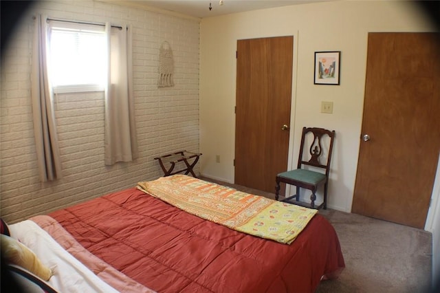 bedroom featuring brick wall and carpet floors