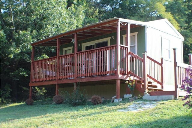 rear view of property with covered porch and a lawn
