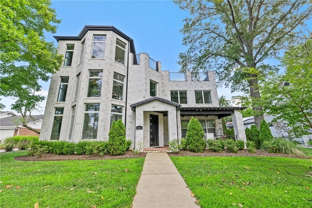 view of front of property featuring a front yard and brick siding